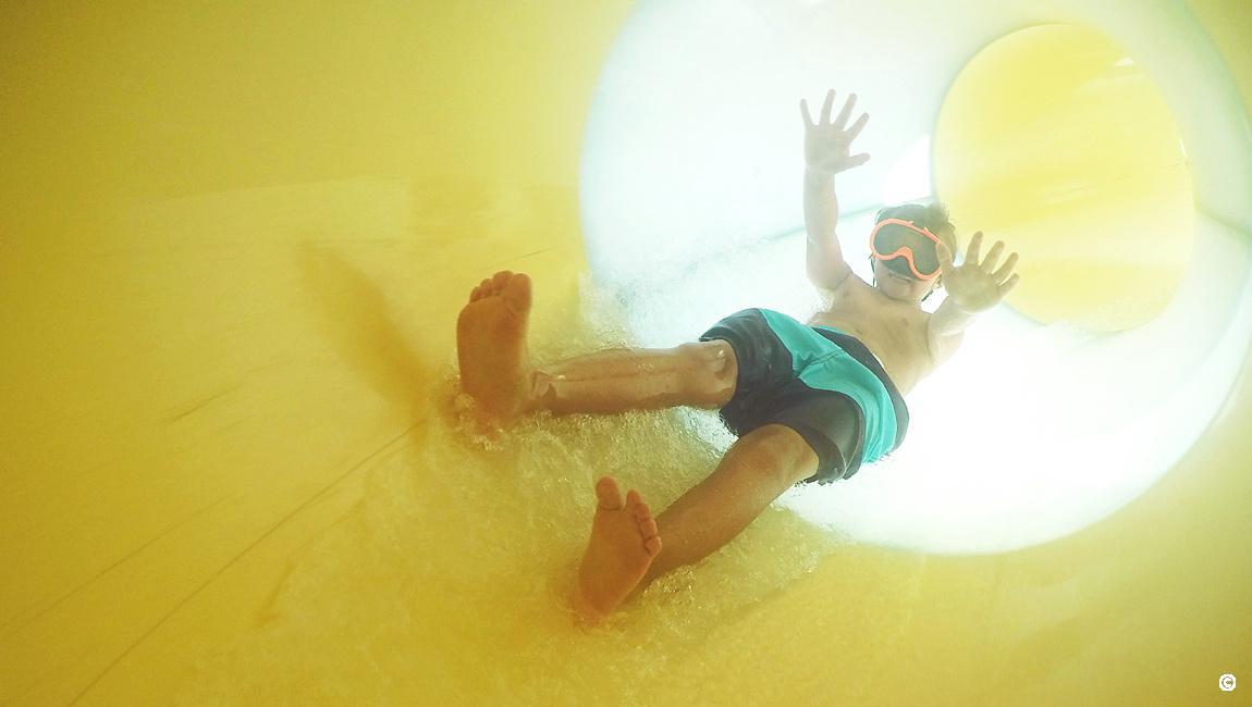 Boy wearing goggles going down the Crown Reef waterpark slide