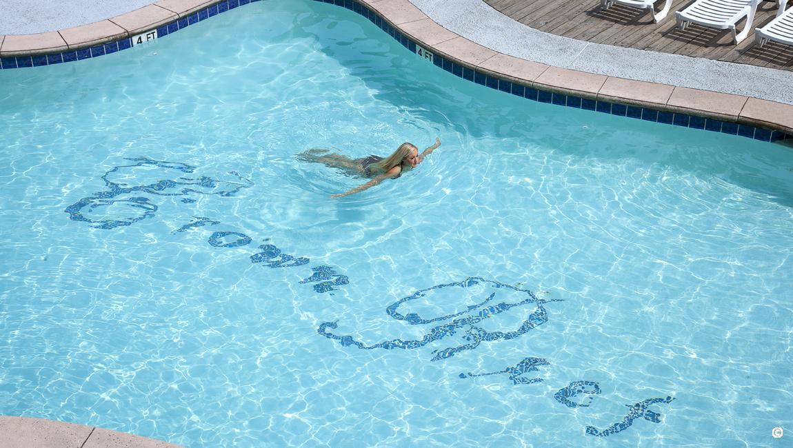 Woman swimming in refreshing pool