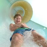 Boy sliding down a Crown Reef waterpark slide